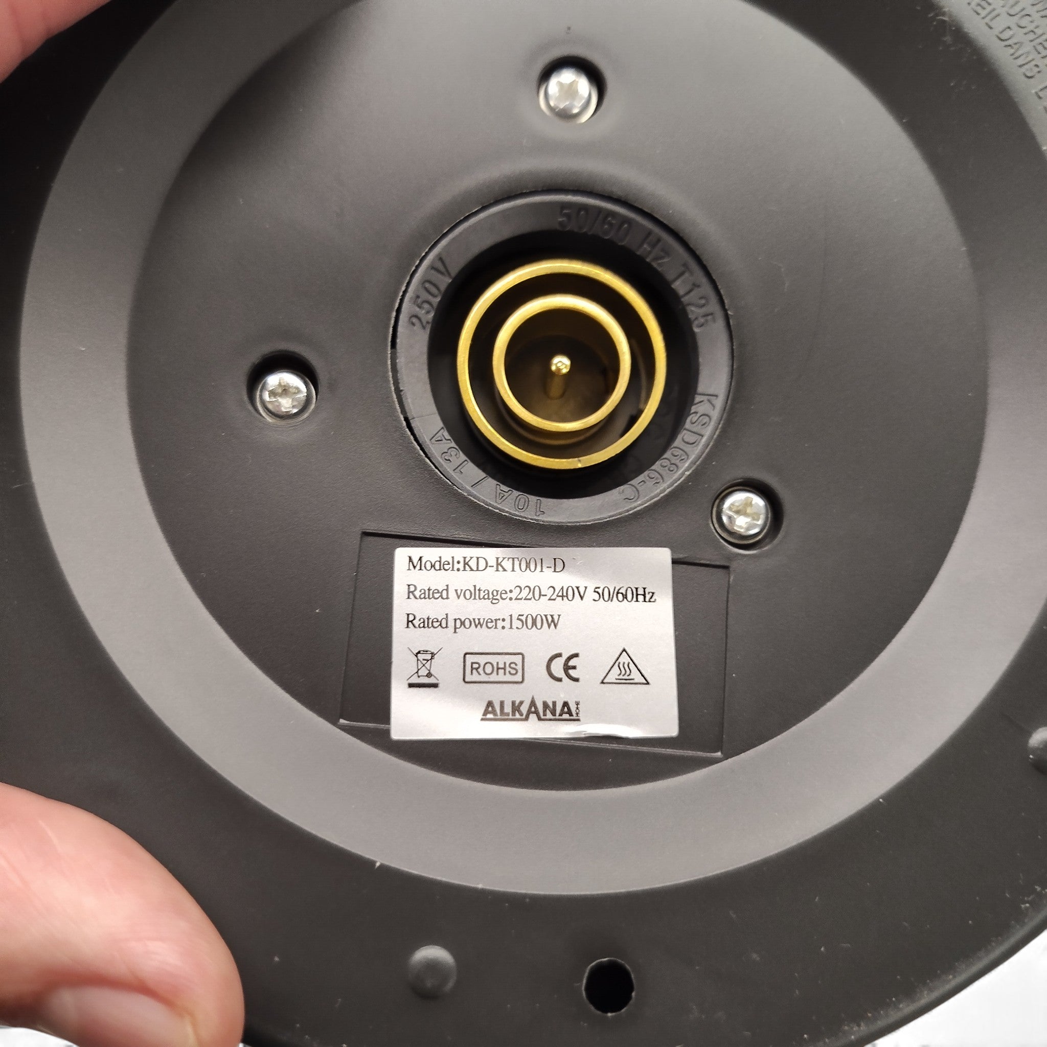 Nahaufnahme des Sockels des Alkana-Wasserkochers KD-KT001-D mit einem Etikett mit 8 l Fassungsvermögen, 220-240 V, 1500 W, Zertifizierungssymbolen und der Marke Alkana Home.