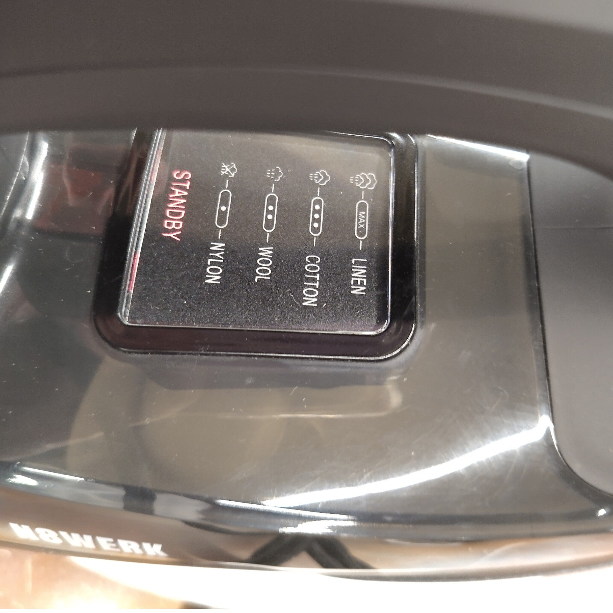 Nahaufnahme des N8werk Dampfbügeleisen-Bedienfelds mit Standby- und Gewebeeinstellungen für Nylon, Wolle, Baumwolle und Leinen - perfekt für knitterfreie Kleidung dank des Turbo-Dampfgenerators und des 3-Kammer-Systems.