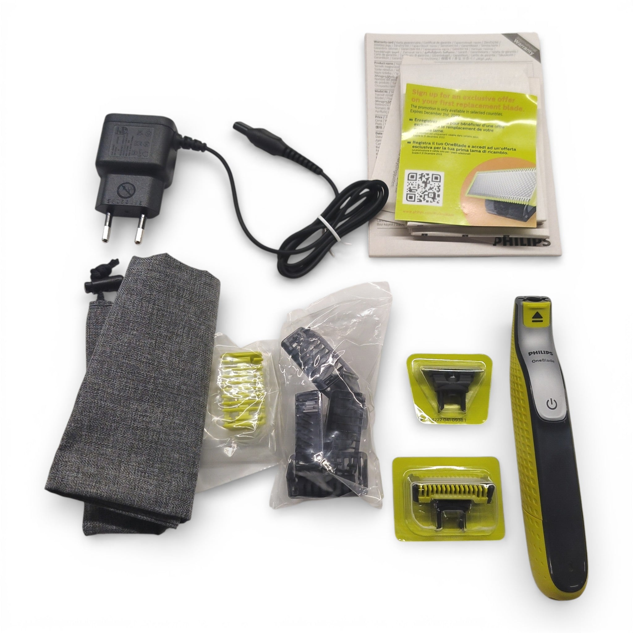 Der Philips OneBlade Face + Body QP2630/30 Hybrid-Rasierer & Bodygroomer (B-WARE) von Philips wird mit Ladeadapter, Bedienungsanleitung, Aufbewahrungsbeutel, drei Aufsätzen und Griff auf einer weißen Oberfläche gezeigt.