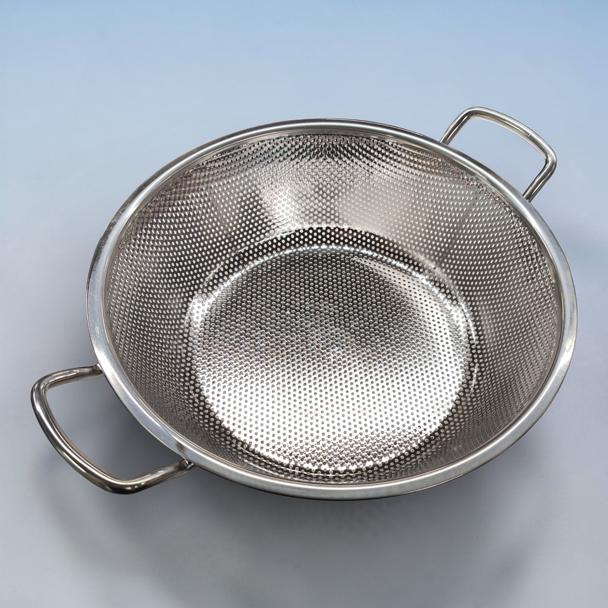 Die QVC Wilkinson Vulcan BBQ Edelstahl Grillpfanne (B-Ware) mit 2 Griffen und einem Durchmesser von 32 cm ist vor einem unifarbenen Hintergrund abgebildet und damit eine ideale Ergänzung für Ihr BBQ Grillzubehör.