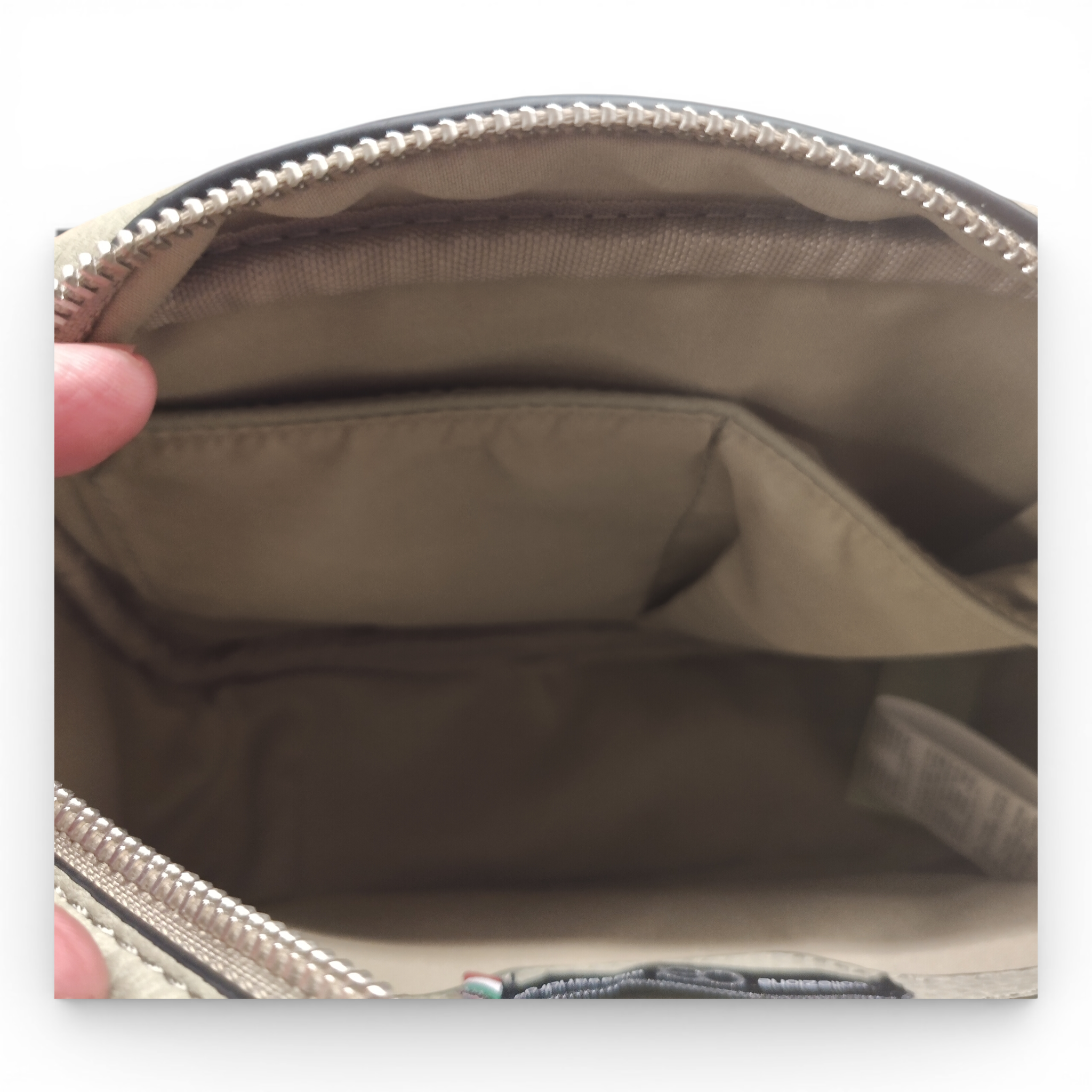Nahaufnahme der Innenseite der beigen Schultertasche Umhängetasche von Collezione Alessandro, Made in Italy, mit dem leeren Hauptfach und zwei kleineren Innentaschen.